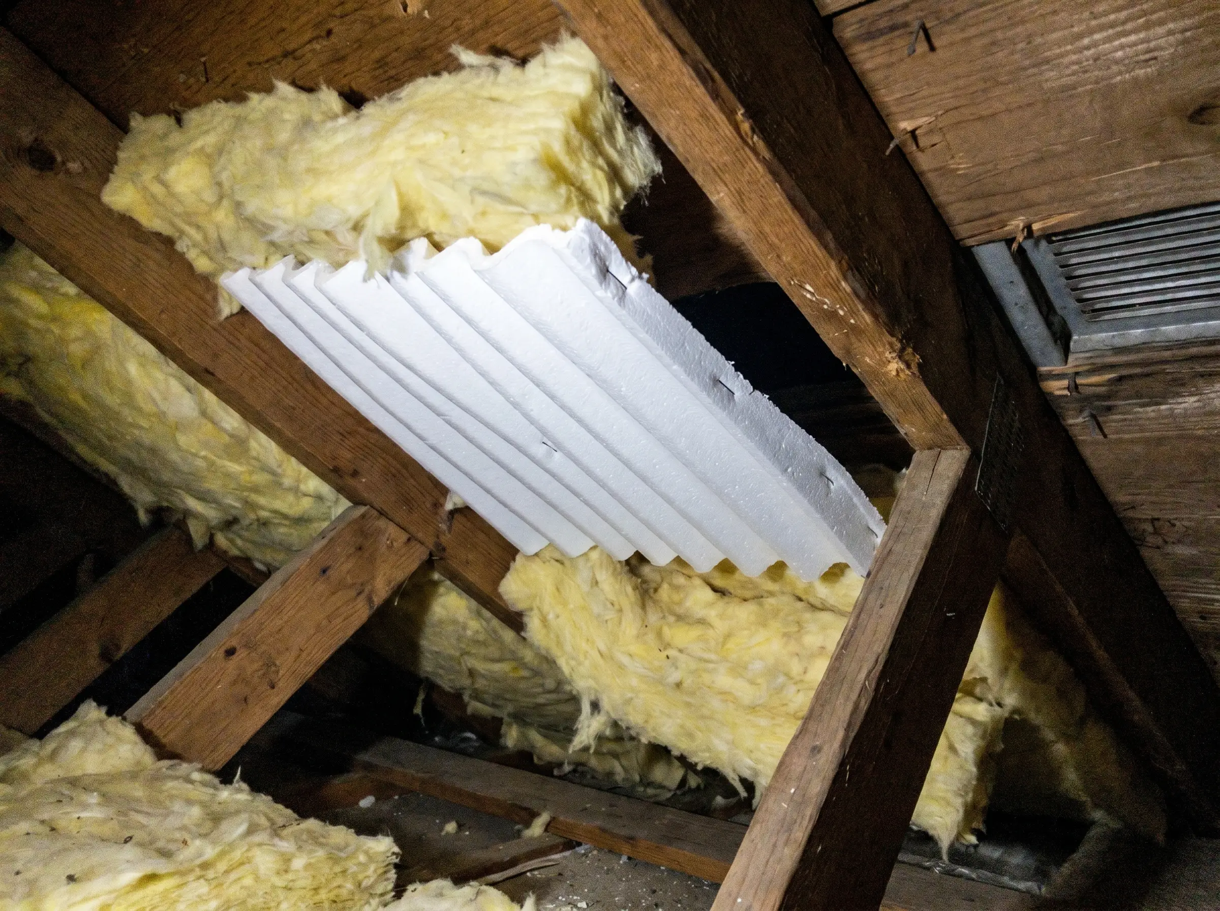 Raw photo: a clean foam baffle installed between rafters keeping the air channel open