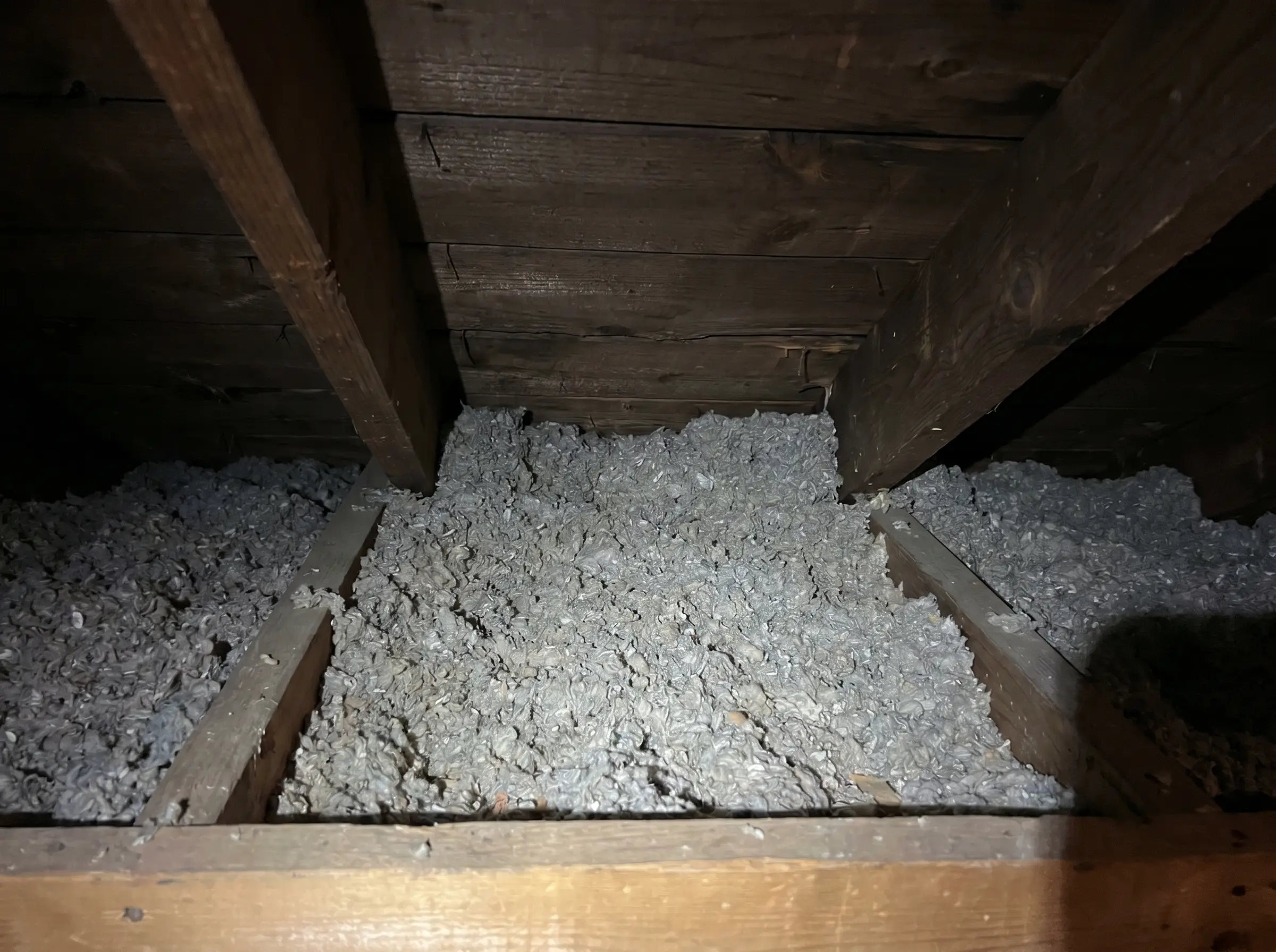 Raw photo: an eave bay stuffed solid with insulation, no air gap
